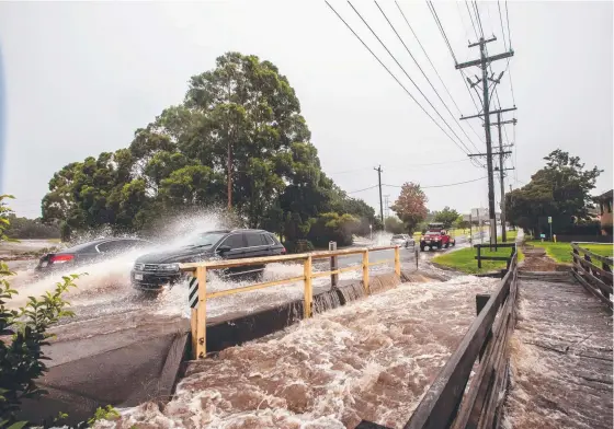  ?? ?? A car negotiates the floodwater­s at East Creek in Toowoomba as heavy rain hits Southeast Queensland. Picture: David Martinelli