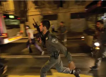  ?? DUSAN VRANIC/THE ASSOCIATED PRESS ?? Israeli policemen look for a possible stabbing suspect in Jerusalem on Wednesday. An attacker stabbed and wounded a woman as she was about to board a bus near a transit station in West Jerusalem, police say.