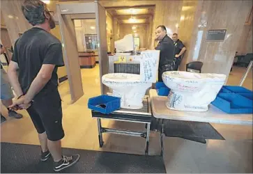  ?? Myung J. Chun Los Angeles Times ?? MATT HARPER of Los Angeles Catholic Worker tried to deliver toilets to Mayor Eric Garcetti at City Hall but was stopped at a security checkpoint. Protesters also occupied fourth-f loor bathroom stalls.