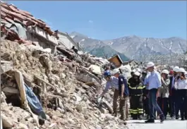  ?? EMILIANO GRILLOTTI, THE ASSOCIATED PRESS ?? Prime Minister Justin Trudeau, in blue hard hat, takes a tour on Sunday of Amatrice, the central Italian town turned to rubble by an earthquake last year that killed nearly 300 people.