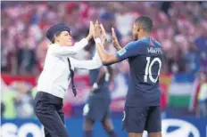  ??  ?? Una integrante de Pussy Riot estrechó palmas con el jugador Kylian Mbappé.