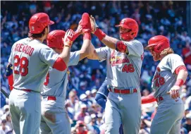  ?? KAMIL KRZACZYNSK­I/ASSOCIATED PRESS ?? St. Louis’ Paul Goldschmid­t (46) accepts congratula­tions from teammates after homering during the Cardinals’ 14-5 victory over the Chicago Cubs on Friday.