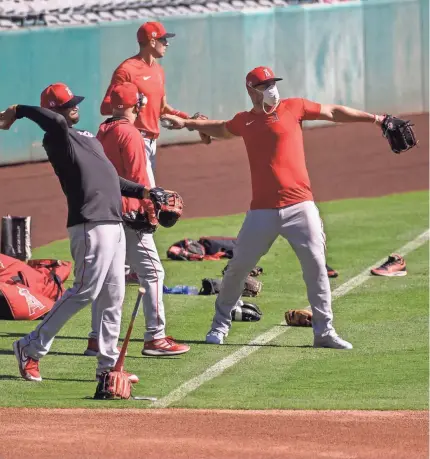  ?? ANGELS BASEBALL/POOL PHOTO VIA USA TODAY SPORTS ?? Angels outfielder Mike Trout, far right, and teammates try to adjust to arguably the strangest season in baseball history.