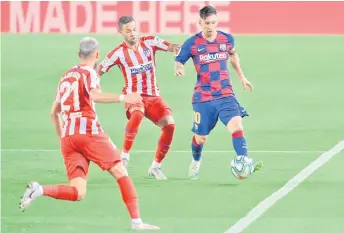  ?? — AFP photo ?? Barcelona’s forward Messi (right) challenges Atletico Madrid’s Brazilian defender Renan Lodi during the Spanish La Liga match at the Camp Nou stadium in Barcelona.