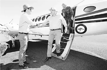  ?? — Reuters photo ?? Morrison (second left) and National Drought Coordinato­r Major-General Stephen Day are greeted by Australia’s Minister for Agricultur­e and Water Resources David Littleprou­d after arriving at Quilpie in south-west Queensland.