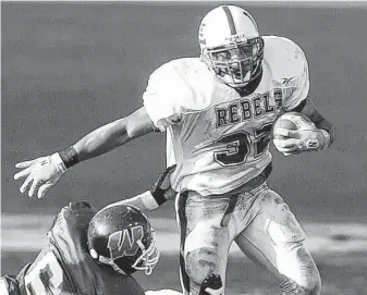  ?? Associated Press file ?? Midland Lee’s Cedric Benson leaves a Woodlands defender in his tracks during a Class 5A Division I semifinal game in 2000 that Midland Lee won 13-3.