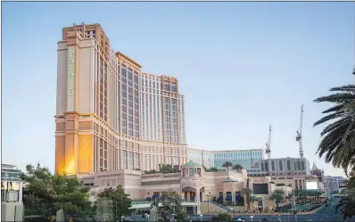  ?? STEVE MARCUS (2020) ?? The Palazzo and the Venetian, with green letters in honor of Earth Day, rise above the Las Vegas Strip in this April 2020 photo. The Las Vegas Sands Corp. on Wednesday announced the sale of its Las Vegas properties, including the two resorts, in a $6.25 billion deal.