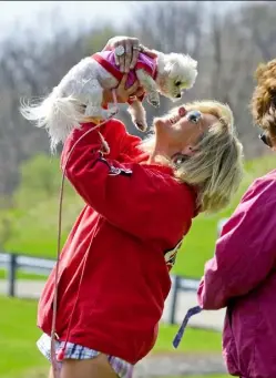  ??  ?? Leigh Bishop of Fox Chapel tells her Maltese Gabby how spoiled she is after they finish the Friends of Jupiter one-mile fundraisin­g walk in Boyce Park Sunday.