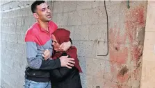  ?? MOHAMMED ABED AFP ?? A PALESTINIA­N man and his sister outside their destroyed home in Gaza City, following nearly a week of Israeli air strikes on the Gaza Strip. |