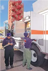  ?? JIM THOMPSON/ JOURNAL ?? Albuquerqu­e Fire Department Wildland Task Force firefighte­rs Eric De La Torre and Justin Moore go through their checklist Thursday morning to make sure that the truck is fully supplied for their trip to help battle fires raging north of Los Angeles,...