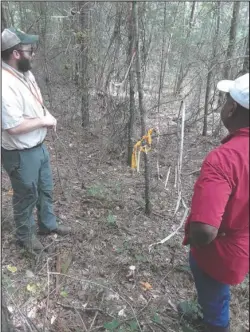  ?? Submitted photo ?? SITE VISIT: Justin Mallett, county forester for the Arkansas Department of Agricultur­e-Forestry Division, and Eundra Boles, a landowner approved for Environmen­tal Quality Incentives Program cost-share funds for forestry conservati­on practices, inspect the corners of Boles’ property during a site visit. The property boundaries are properly marked with flagging tape.