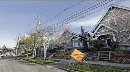  ?? PHOTOS BY ELAINE THOMPSON / ASSOCIATED PRESS 2017 ?? A four-story mixed-use building takes shape at the end of a street of older, singlefami­ly homes in Seattle. City officials want to let developers erect taller and denser buildings in core areas of the city, and require them to include units that...