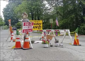  ?? Mike Pesarchick/Post-Gazette ?? Decoration­s adorn the area around a sinkhole that’s formed at the intersecti­on of Ninth Street and Virginia Avenue in Oakmont. Residents of the borough have been adding decoration­s while they wait for the sinkhole to be fixed.