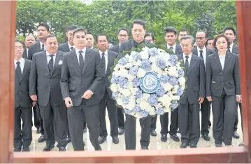  ??  ?? Democrat executives and ex-MPs lay a wreath before the statue of King Prajadhipo­k at parliament yesterday on the former king’s memorial day. The party has seen some of its members return after they left to join the People’s Democratic Reform Committee.