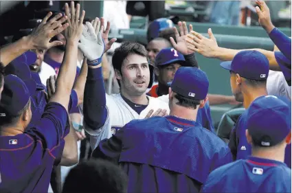  ?? PHOTOS by TIM HEITMAN/ USA TODAY ?? Rangers third baseman Joey Gallo, a former Bishop Gorman standout, accepts congratula­tions after hitting a two-run home run in the third inning of Texas’ 15-2 victory over the Chicago White Sox on Tuesday in Arlington, Texas. Gallo went 3-for-4 with...