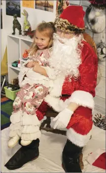  ?? Brodie Johnson • Times-Herald ?? Three-year-old Lindsey Thweatt is dressed in a Christmas outfit as she sits on Santa’s knee and shares her Christmas list with the Jolly Old Elf. Santa is making his rounds to visit with as many children as possible before beginning his Christmas Eve journey.