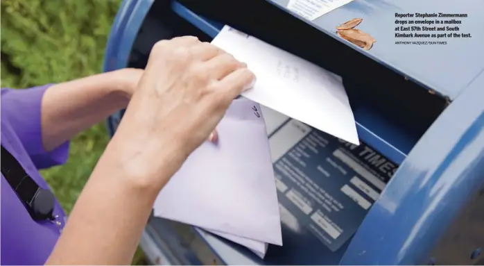  ?? ANTHONY VAZQUEZ/SUN-TIMES ?? Reporter Stephanie Zimmermann drops an envelope in a mailbox at East 57th Street and South Kimbark Avenue as part of the test.