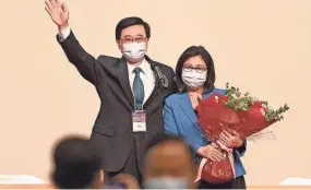  ?? PETER PARKS/AFP VIA GETTY IMAGES ?? John Lee and his wife, Janet, celebrate after Lee was named the city’s new leader Sunday, in Hong Kong.