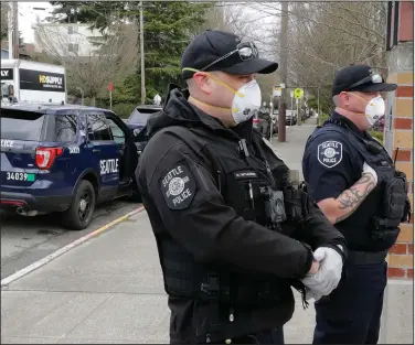  ??  ?? Seattle police officers wear N95 masks for protection against the coronaviru­s as they patrol Thursday. (AP/Ted S. Warren)