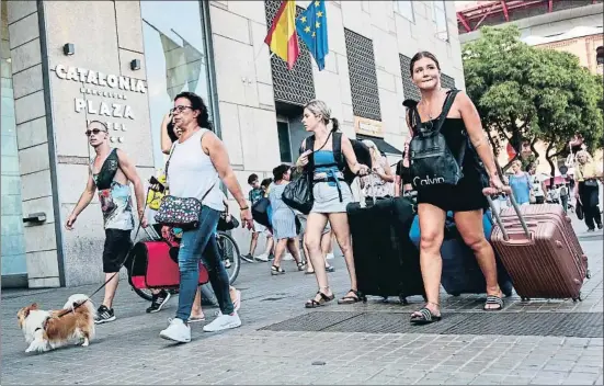  ?? MONTSE GIRALT ?? Buscarse la vida. Muchos clientes de hoteles tienen que llevar sus maletas hacia el transporte público ante la ausencia de taxis