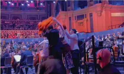  ?? ?? Just Stop Oil protesters holding an orange banner disrupt the Proms. Photograph: Twitter/Just Stop Oil