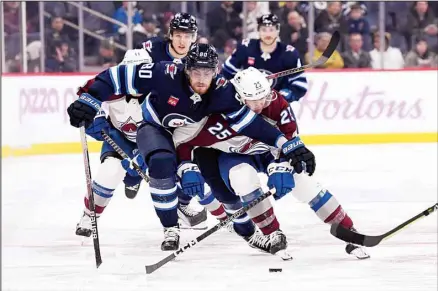  ?? (AP) ?? Colorado Avalanche’s Logan O’Connor (25) and Winnipeg Jets’ Pierre-Luc Dubois (80) battle for the puck during the second period of an NHL hockey game in Winnipeg, Manitoba.