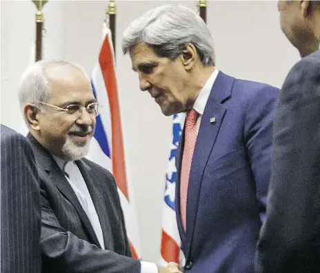  ?? FABRICE COFFRINI / AFP / Gett
y Imag
es ?? Iranian Foreign Minister Mohammad Javad Zarif shakes hands with U.S. Secretary of State John Kerry in 2013.