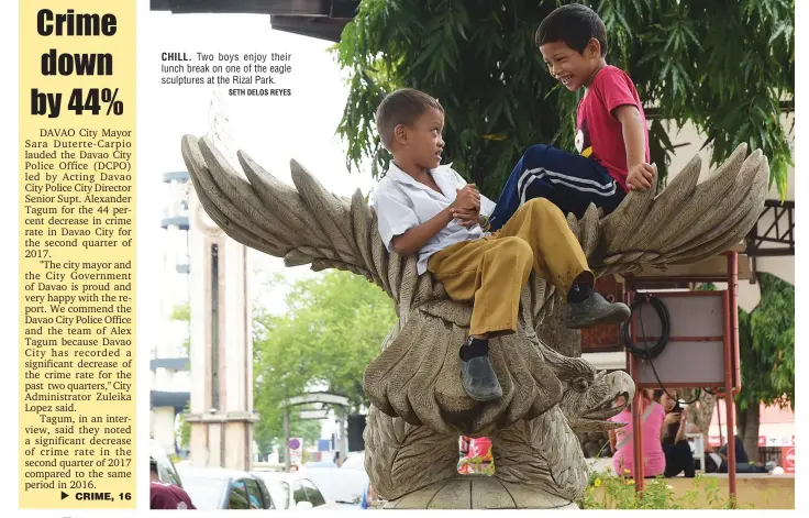  ?? SETH DELOS REYES ?? CHILL. Two boys enjoy their lunch break on one of the eagle sculptures at the Rizal Park.