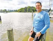  ?? PAUL W. GILLESPIE/ CAPITAL GAZETTE PHOTOS ?? Marathon swimmer Doug Karr, above, races through the Rhode River off Carr’s Wharf in Edgewater on Friday. Karr, left, on the dock at the wharf, had knee surgery in 2018 that ended in infection. Karr had to relearn how to walk and had stopped swimming for 15 years. When the pandemic hit, he felt it was time to get back in the water.