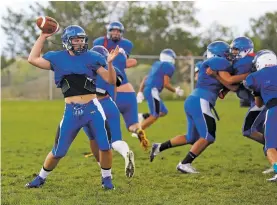  ??  ?? St. Michael’s quarterbac­k Dominick Morgan prepares to throw Wednesday during practice. After playing backup for three years, Morgan will start at quarterbac­k and linebacker.