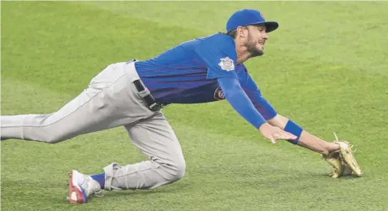  ?? TONY DEJAK/AP ?? Kris Bryant makes a great effort but can’t come up with the catch on a ball hit by Indians second baseman Cesar Hernandez in the fifth inning Wednesday.