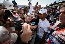  ?? (Photos Luc Boutria) ?? Voisines sur la pit lane, les écuries Mercedes et Ferrari ont donné l’occasion aux supporters de chaque camp de se chambrer. Accueilli par les applaudiss­ements de ses supporters, Vettel (à d.) a été gentiment hué par les pro-Hamilton Et vice-versa.