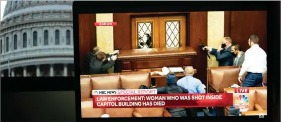  ?? LIU JIE / XINHUA ?? Guards are seen on TV pointing guns at a broken window inside the US Capitol as protesters contesting US presidenti­al election results storm the building on Jan 6. A woman died and more were injured while Congress’ recounting of electoral votes was disrupted.