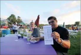  ?? JONATHAN TRESSLER — THE NEWS-HERALD ?? Mentor on the Lake resident Darin Herrera proudly displays his wine-tasting card, all of which he was able to fill out due to the weather Aug. 4, the first day of the two-day Vintage Ohio wine festival at Lake Metroparks Farmpark Aug. 4. Herrera’s...