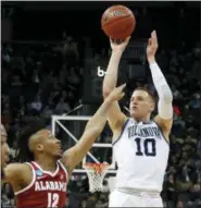  ?? GENE J. PUSKAR - AP ?? Villanova ‘s Donte DiVincenzo (10) sinks a 3-pointer over Alabama‘s Dazon Ingram (12) during the first half of last Saturday’s NCAA tournamen game in Pittsburgh.