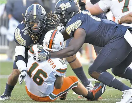  ?? Matt Freed/Post-Gazette photos ?? Pitt’s Avonte Maddox and Dewayne Hendrix take down Miami backup quarterbac­k Evan Shirreffs in the fourth quarter. Maddox had two sacks on the afternoon.