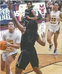  ?? The Sentinel-Record/Grace Brown ?? Q Lake Hamilton’s Hayleigh Wyrick (23) drives in for a shot as Hot Springs’ KaLariya McDaniel (12) looks to block in Tuesday’s game at Wolf Arena. The Lady Wolves won 56-34.