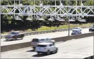  ?? Elise Amendola / Associated Press file photo ?? Cars pass under toll sensor gantries hanging over the Mass Pike in Newton.