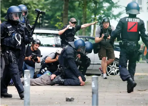  ?? Foto: dpa/Sebastian Willnow ?? Polizisten nehmen bei Anti-G20-Protesten im Sommer 2017 in Hamburg unter Beobachtun­g von Journalist­en einen Aktivisten fest.