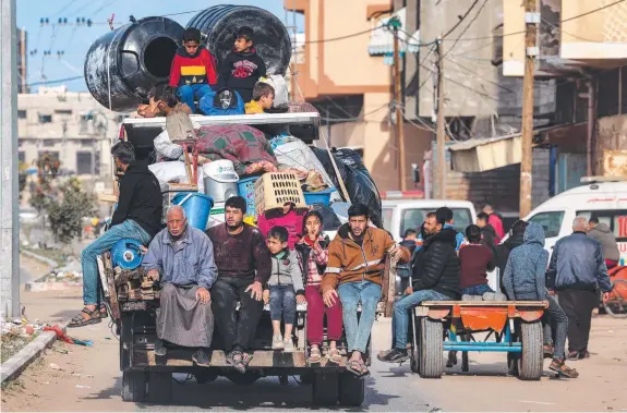  ?? ?? Palestinia­n families in the southern Gaza Strip city of Rafah flee with their few possession­s ahead of a threatened Israeli ground offensive. Picture: AFP