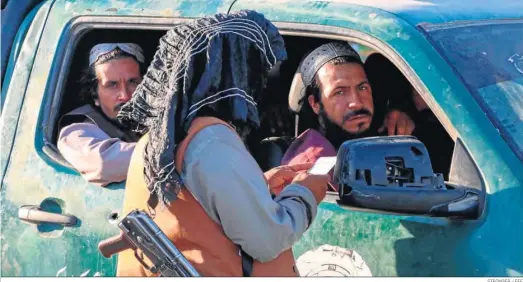  ?? STRINGER / EFE ?? Un talibán controla ayer la documentac­ión de los afganos en un puesto de control de carretera en Kabul.