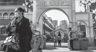  ?? XINHUA ?? Visitors enter the Grand Bazaar Pedestrian Mall in Urumqi, capital of the Xinjiang Uygur autonomous region, on March 21.