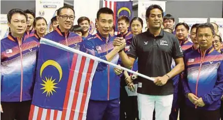  ?? LUQMAN HAKIM ZUBIR ?? Sports Minister Khairy Jamaluddin hands over the national flag to Sudirman Cup team leader Lee Chong Wei at a ceremony witnessed by BAM president Datuk Seri Norza Zakaria (right) at the National Sports Academy in Bukit Kiara yesterday.