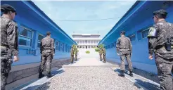  ?? HWANG KWANG-MO/YONHAP ?? Four North Korean soldiers, center far, and four South Korean soldiers, right and left, stand at the border village of Panmunjom in the Demilitari­zed Zone, South Korea, on Thursday.