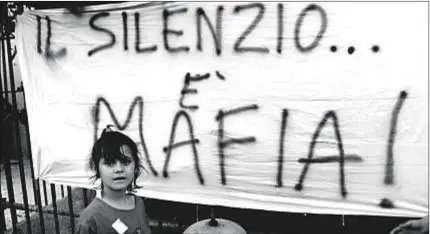  ??  ?? Una pancarta critica la ley de la omertá, el código de honor que prohíbe informar sobre las actividade­s delictivas de la mafia