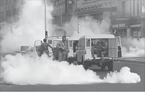  ??  ?? Riot police in Adderley Street engulfed in tear gas during the 1976 uprising.