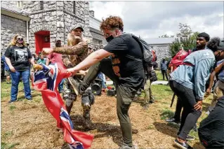  ?? ALYSSA POINTER / ALYSSA.POINTER@AJC.COM ?? Protesters fight it out during a demonstrat­ion Aug. 15 in Stone Mountain. Several dozen people waving Confederat­e flags, many of them armed and wearing military gear, gathered in downtown Stone Mountain where they clashed with counterpro­testers.