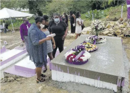  ??  ?? Family members of the late Juliet Wilson (from left) Michelle Johnson Dennis, her sister; niece Erin Artwell; daughter Kara Edwards; and niece Jodian Lloyd stand close to the grave in the final moments of yesterday’s service.