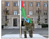  ?? (AP/Azerbaijan­i Presidenti­al Press Office) ?? Azerbaijan­i President Ilham Aliyev kisses an Azerbaijan­i National Flag on Sunday in the city of Khankendi, which is also known as Stepanaker­t to Armenians, in Azerbaijan.