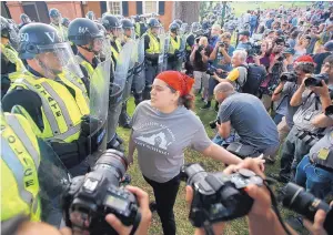  ?? STEVE HELBER/ASSOCIATED PRESS ?? A protester confronts police on the campus of the University of Virginia during a rally to mark the anniversar­y of last year’s Unite the Right rally in Charlottes­ville, Va., on Saturday.